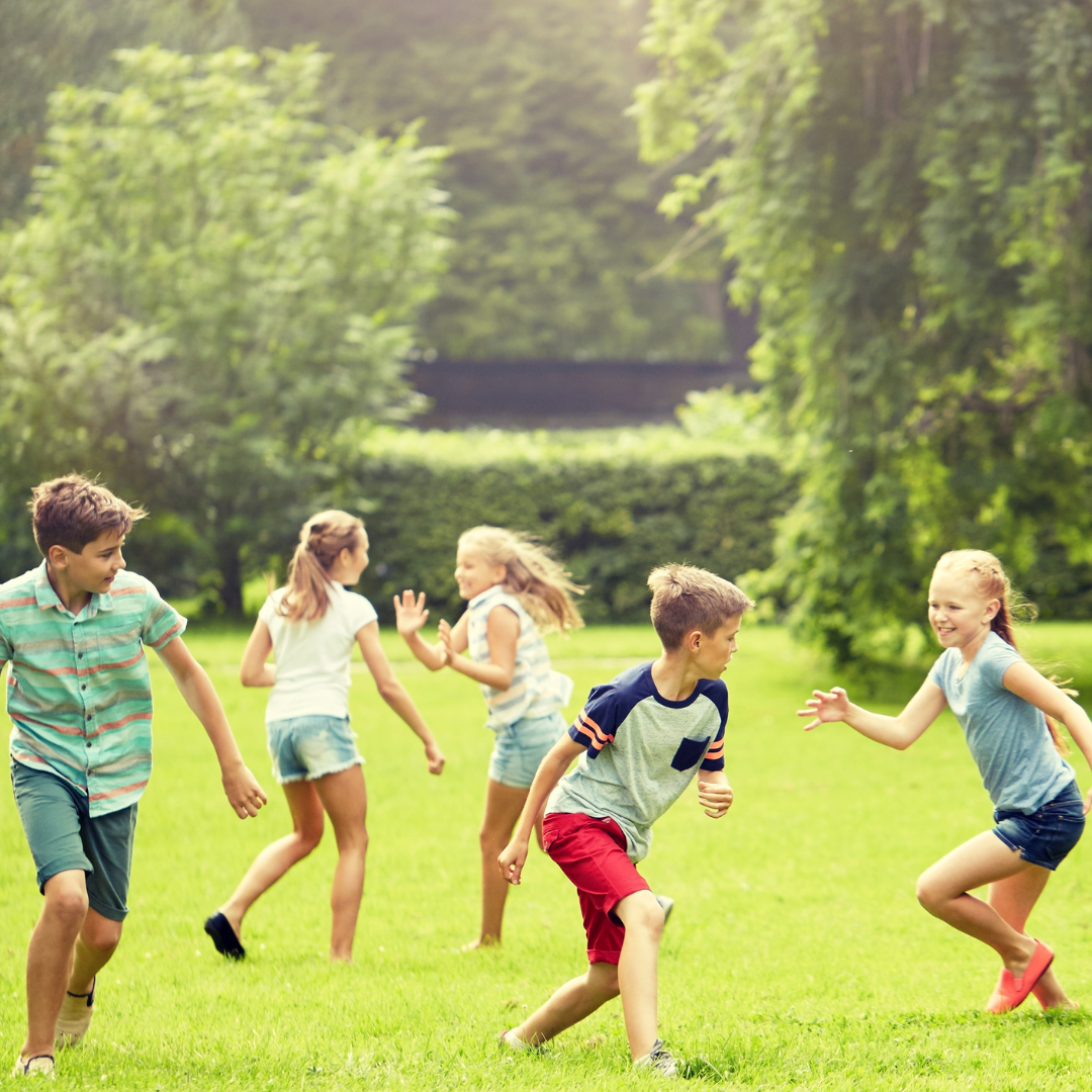 Children playing a game in a green grass field.